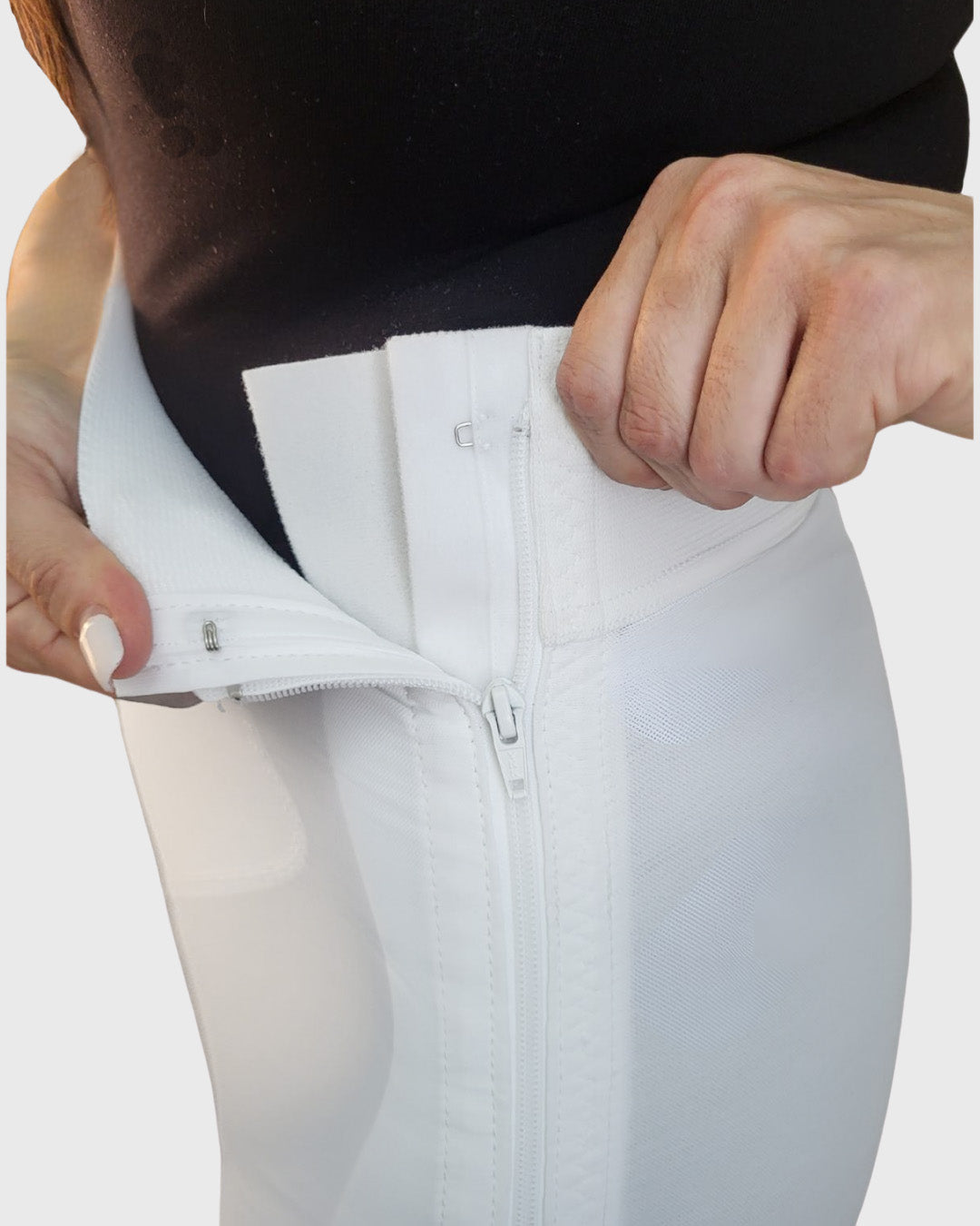 View of the white above knee compression girdle demonstrating the hook and eye closure