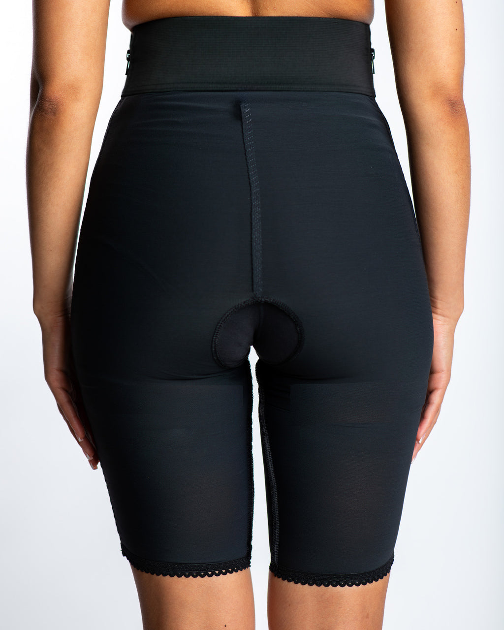 Rear view of black above knee compression girdle with contact closure for surgical support