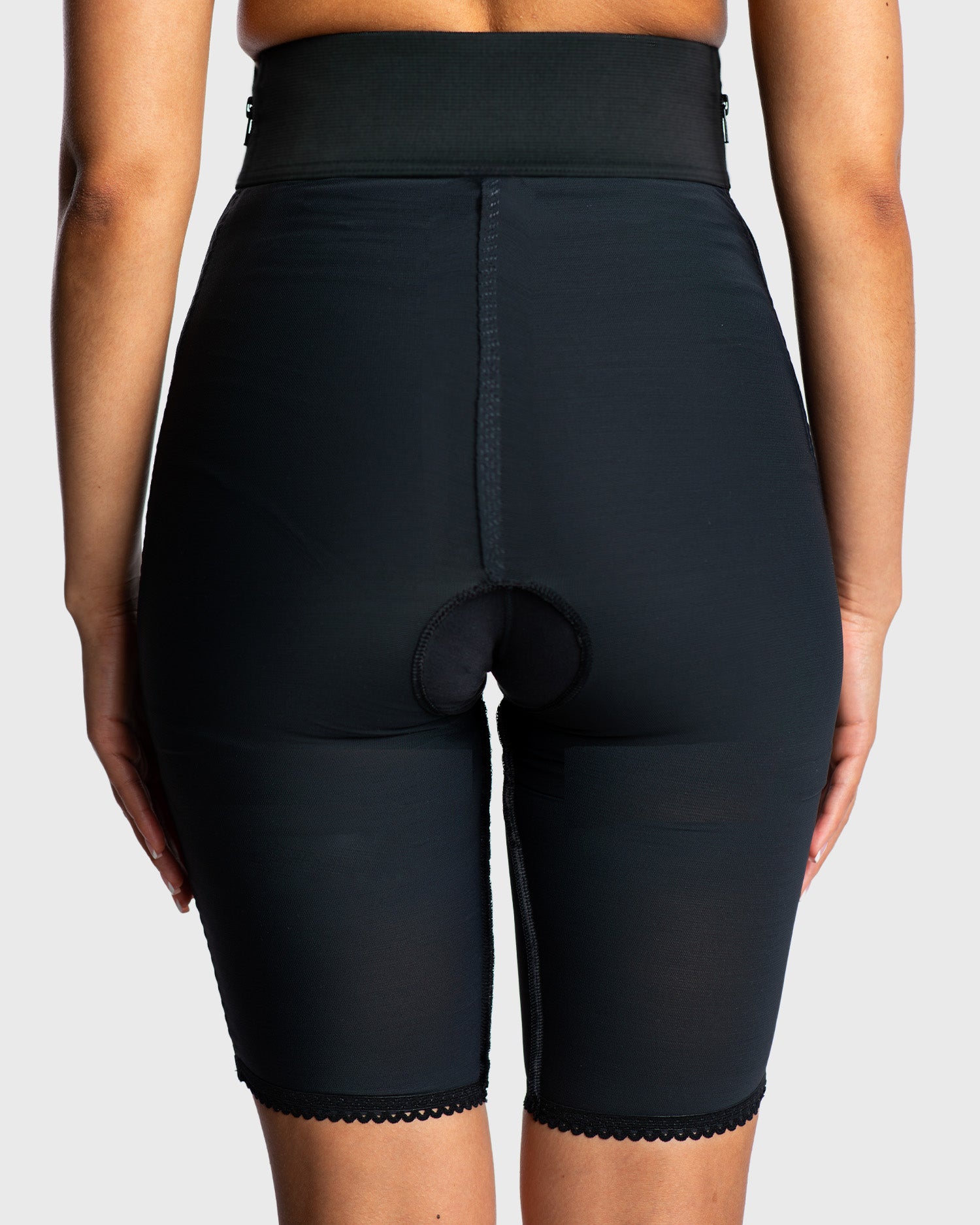 Rear view of black above knee compression girdle with contact closure for surgical support