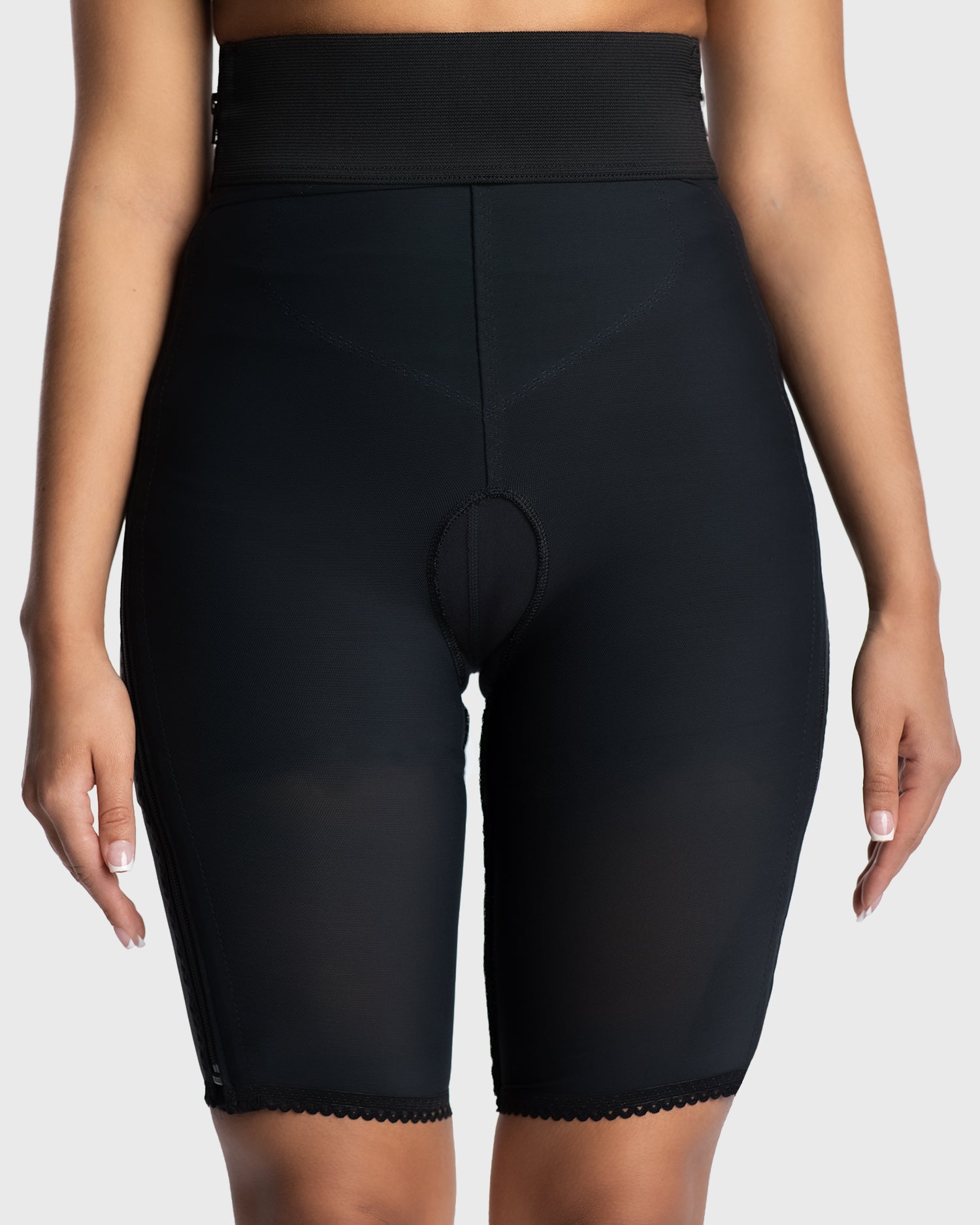 Front view of black above knee compression girdle with contact closure and front zipper for post-surgical recovery