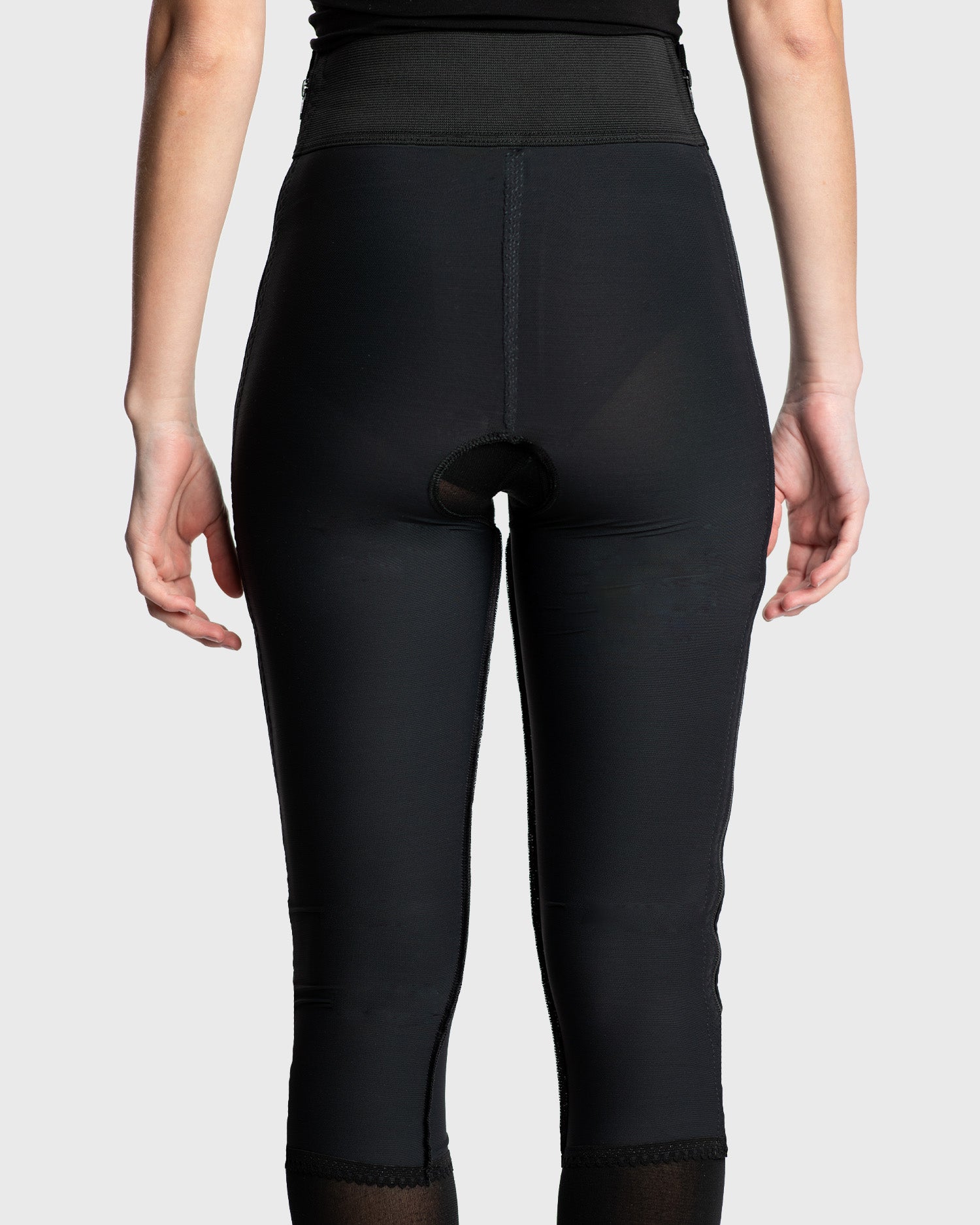 Rear view of black below knee compression girdle with contact closure for recovery