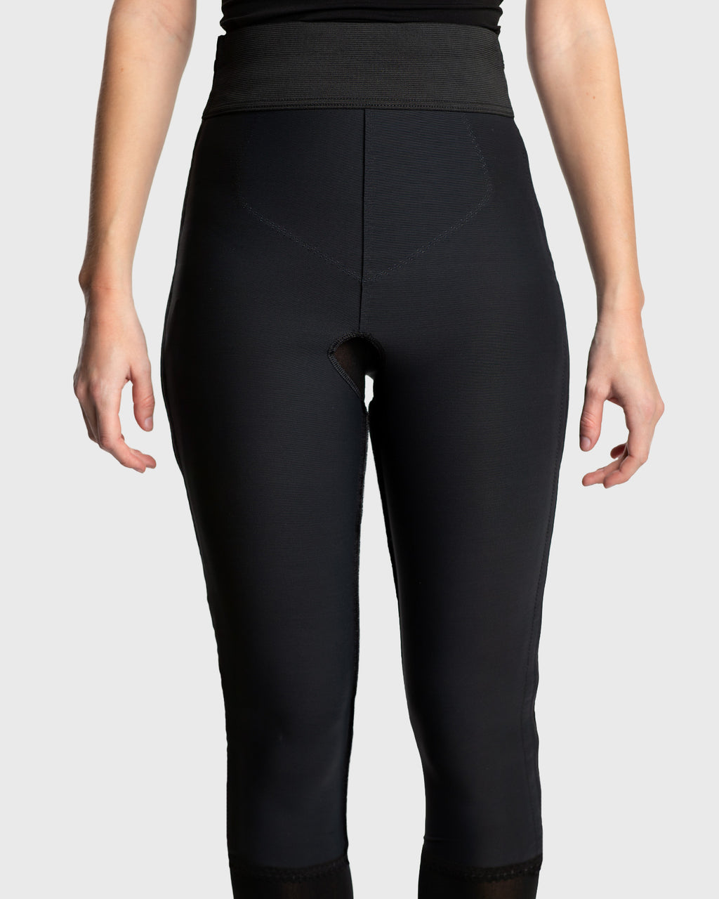 Front view of black below knee compression girdle with contact closure and front zipper for post-surgical recovery