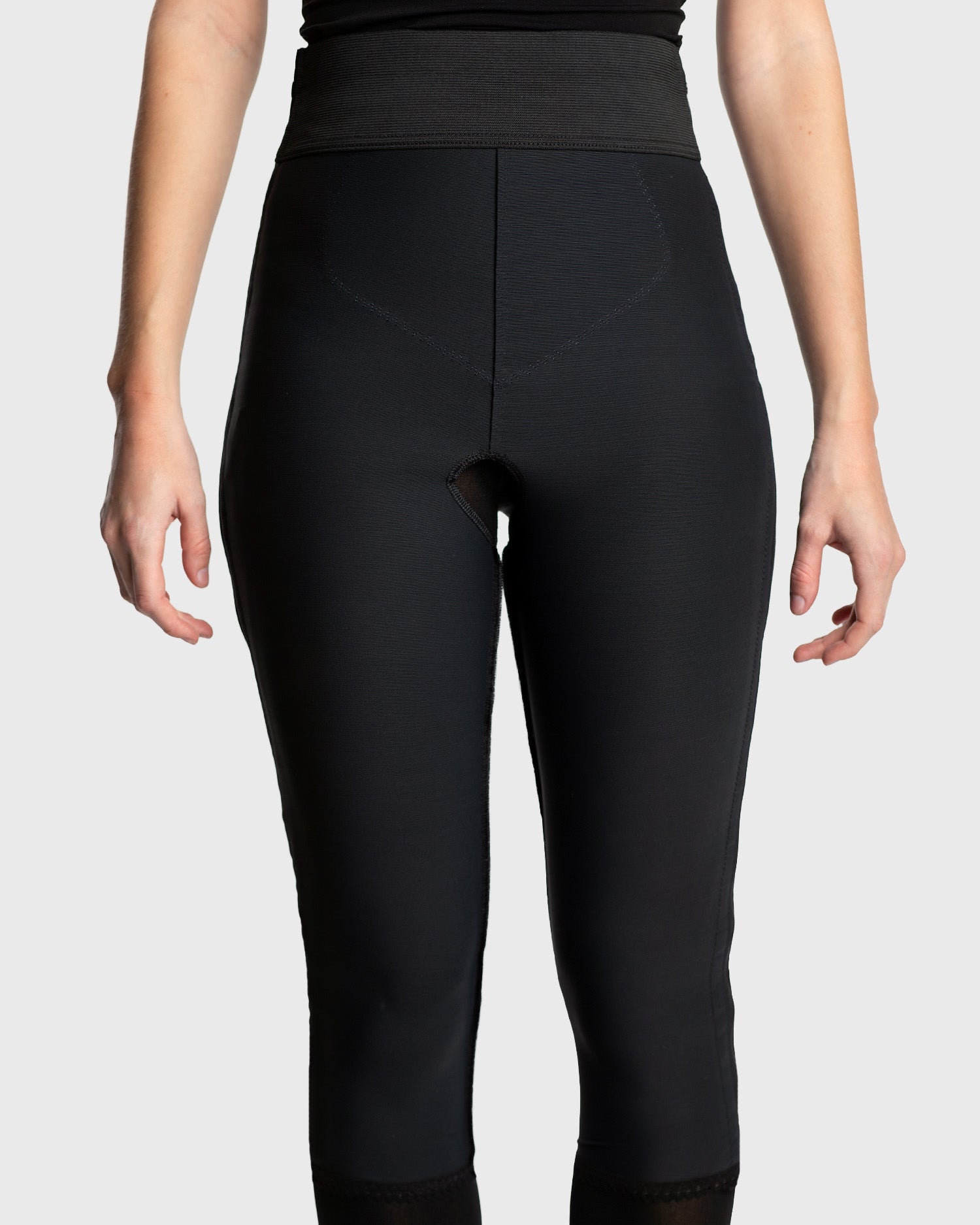 Front view of black below knee compression girdle with contact closure and front zipper for post-surgical recovery