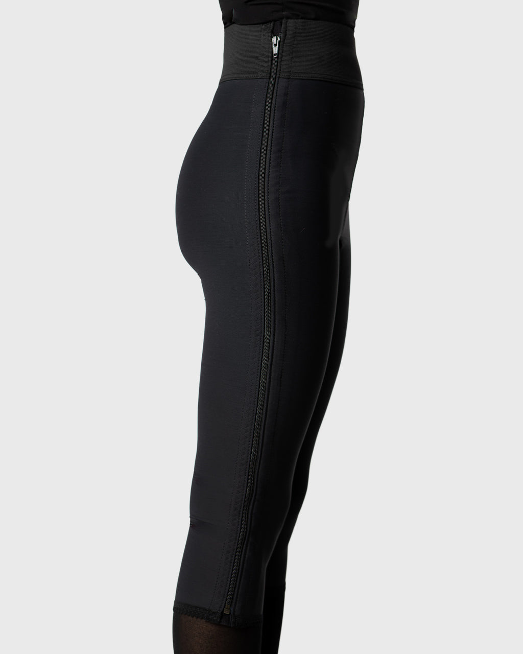 Side view of black below knee compression girdle with hook and eye closure for post op shapewear