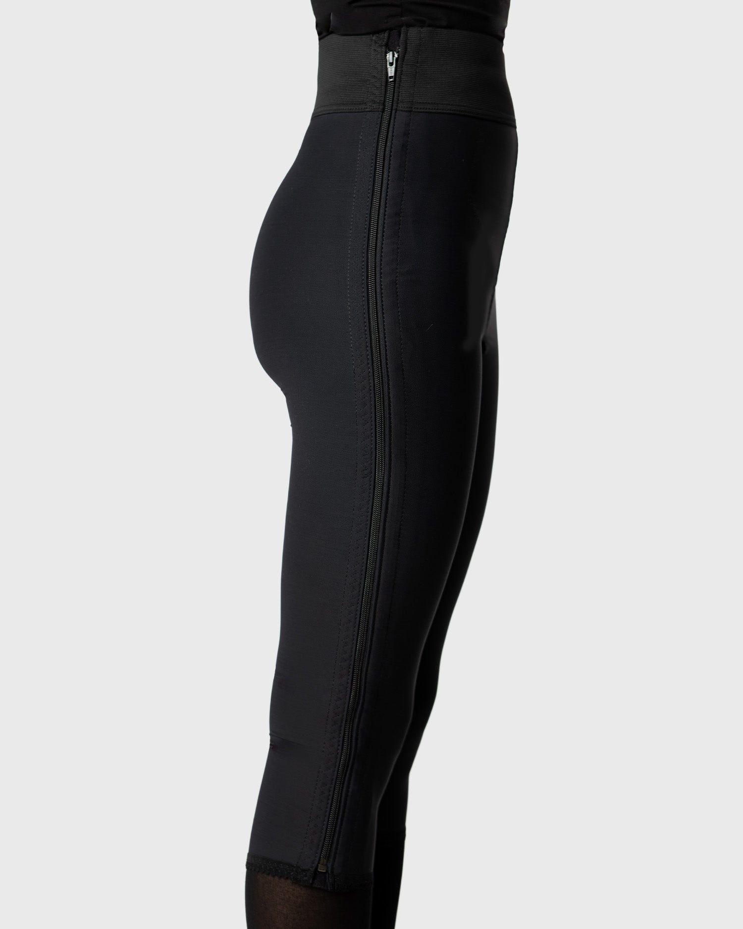 Side view of black below knee compression girdle with hook and eye closure for post op shapewear