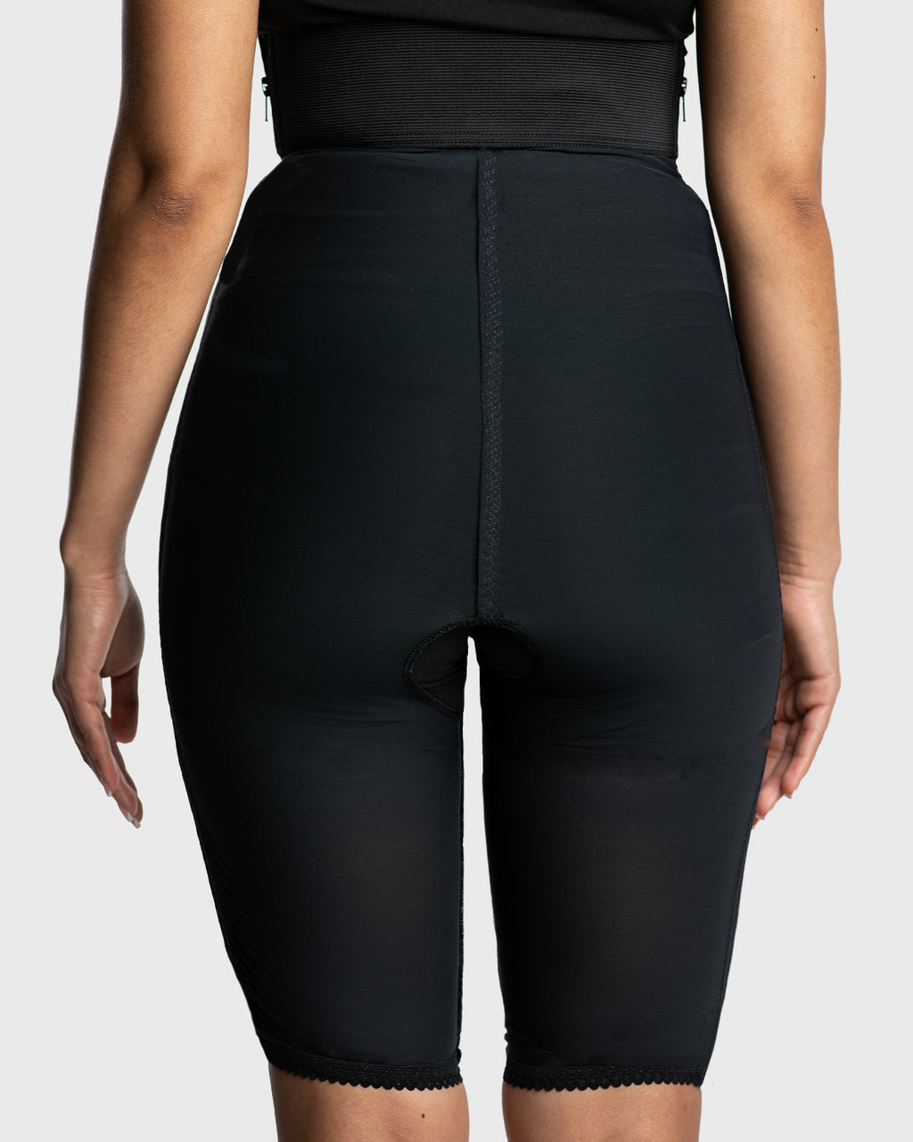 Rear view of black high waist above knee compression girdle with hook and eye closure for surgical support