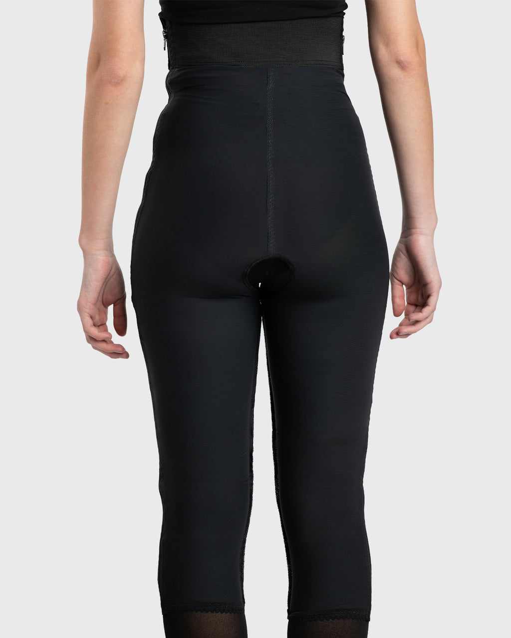 Rear view of black high waist below knee compression girdle with contact closure for recovery