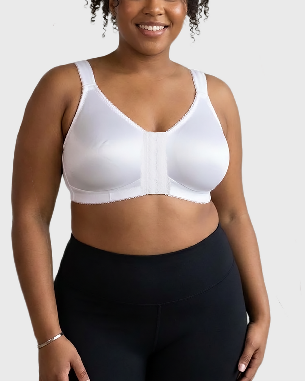 Curvy model wearing white post-surgical compression bra with supportive fit