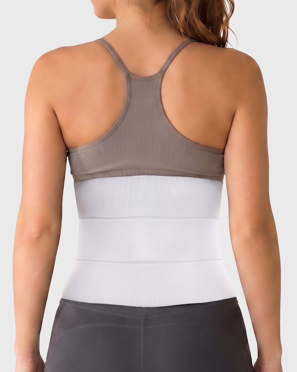 Young woman wearing Frank Stubbs Universal Abdominal Binder 9" White for post-surgical compression support