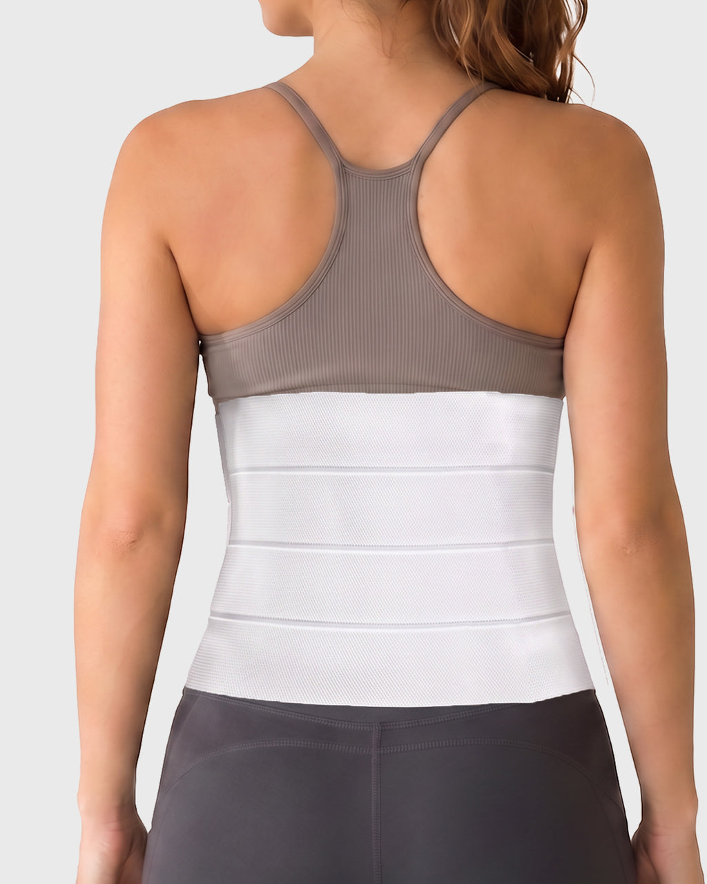 Frank Stubbs Universal 12-Inch Abdominal Binder on female model, rear view, showing full abdominal coverage and adjustable compression