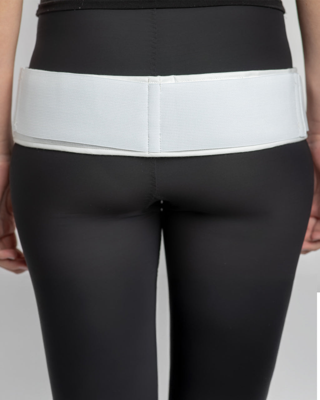 Rear view of double pull trochanter belt providing targeted compression and support to the hips and sacroiliac joint area