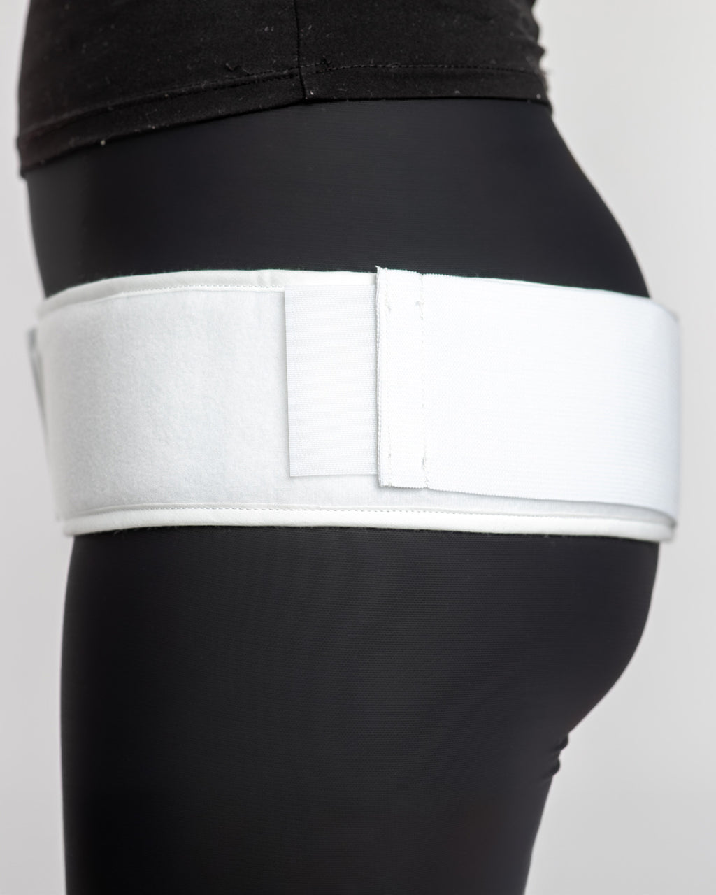 Side view of double pull trochanter belt with adjustable contact closure and compression straps for hip support and stability